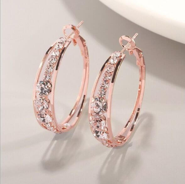 Rose gold hoop earrings with crystals, perfect for stylish women, enhancing elegance in any outfit.