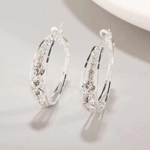 Elegant silver hoop earrings with sparkling crystal embellishments, perfect for women's fashion.