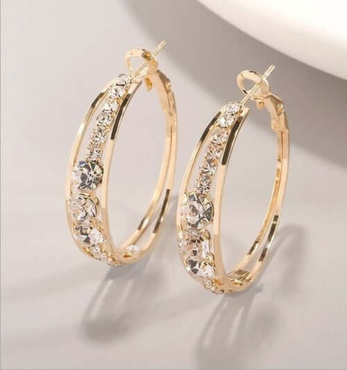 Gold hoop earrings adorned with sparkling crystals, perfect for women's fashion and jewelry collections.